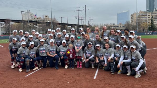 Villanova's womens softball team poses for a picture with two Team Impact children