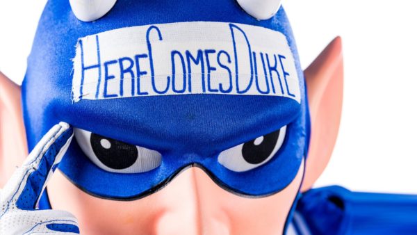 Duke's blue devil mascot with a sign on his head reading "Here Comes Duke"
